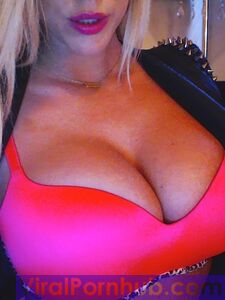 La blonde souriante Xo Gisele joue avec ses énormes seins devant la caméra.